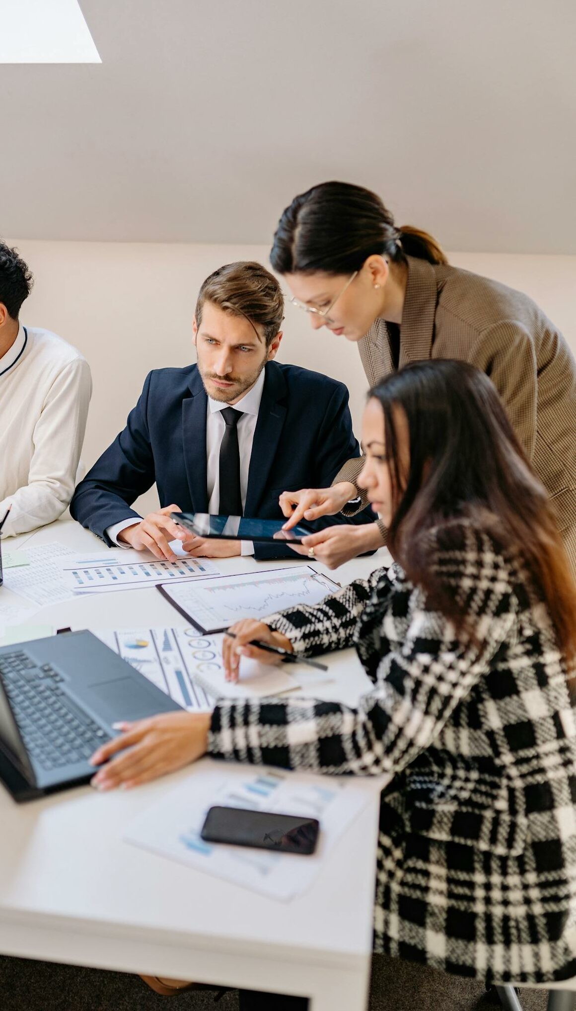 Professionals engaged in a meeting discussing plans in a modern office setting.